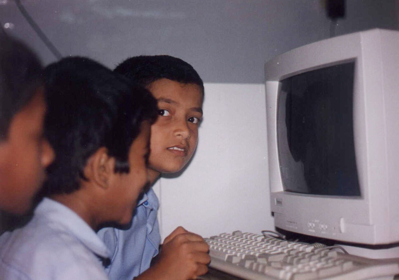 Indian schoolchildren exploring computers together during a hands-on learning workshop